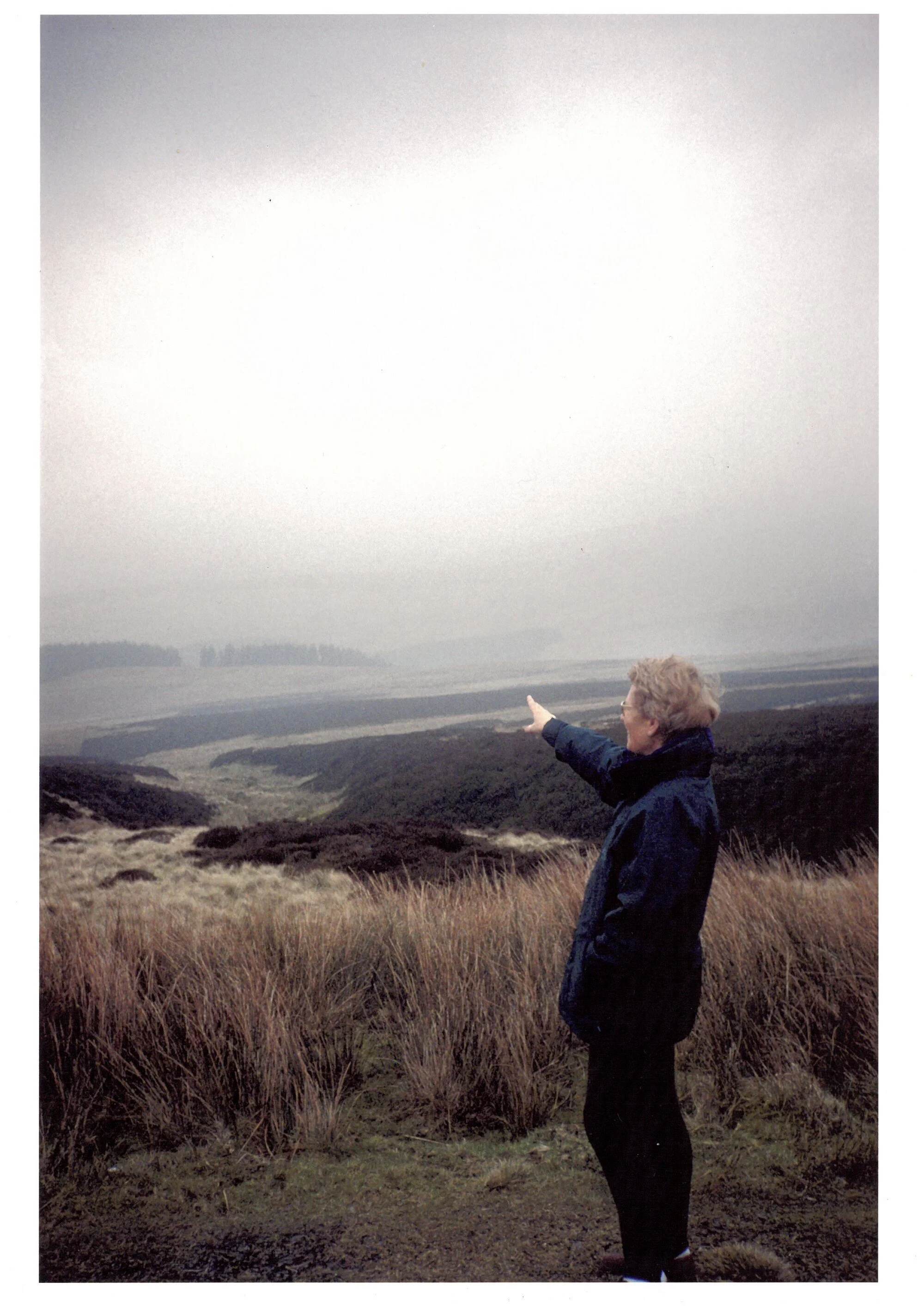 Pat Evans pointing toward the site on the Berwyn mountains, photographed years after the event.
