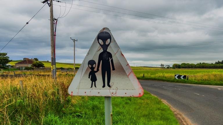 A Scottish road sign showing two aliens
