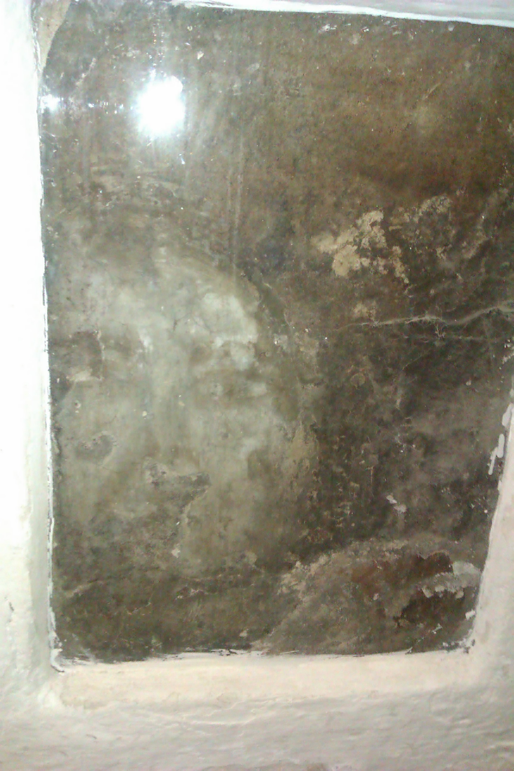 La Pava, the face that replaced the destroyed original, preserved behind glass in the wall of María Gómez's house and photographed in 2012.